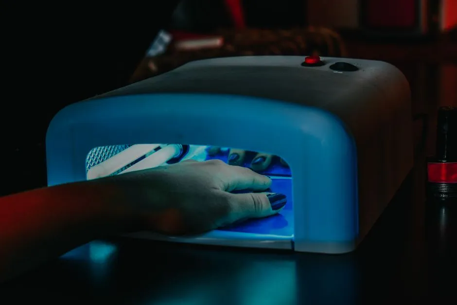 Hand under LED-lampa som härdar gelnaglar — UV-exponering en gång varannan vecka