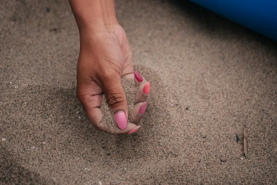 Press-on naglar bäst i test 2026 hand med rosa manikyr i sandstrand